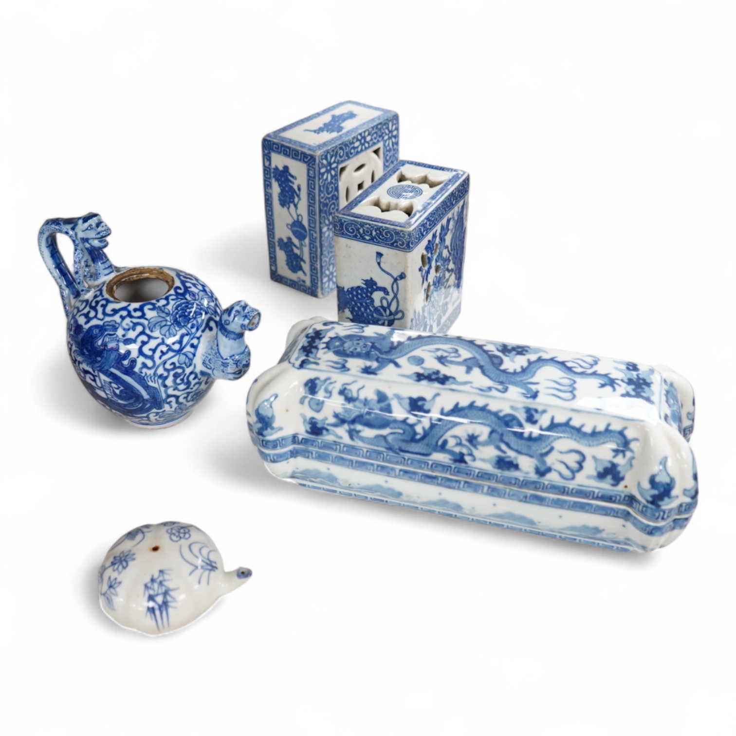 A group of Chinese blue and white comprising a dish and cover, two pillows, waterdropper and a teapot, largest 26cm wide